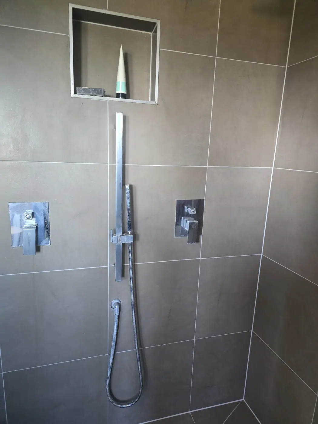 Dark tiled shower before regrouting